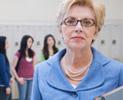 A principal stands in a school hallway